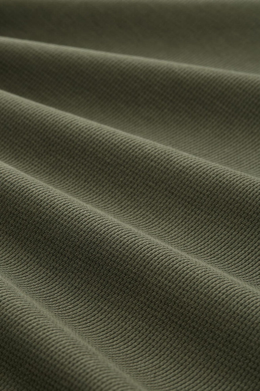 Olijfgroene wafelstof stof, plooien.
