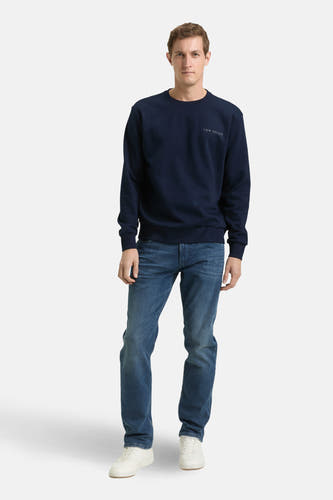 Blauwe sweater van TOM TAILOR met lange mouwen, gecombineerd met jeans en witte sneakers.
