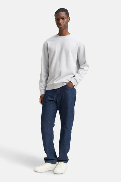 Pull gris de TOM TAILOR, avec des manches longues, associé à des jeans foncés et des baskets blanches.