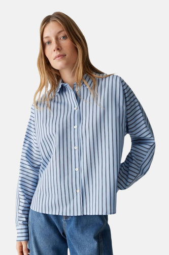 Chemise bleue rayée avec longues manches d'OPUS, à col boutonné et un jean visible.