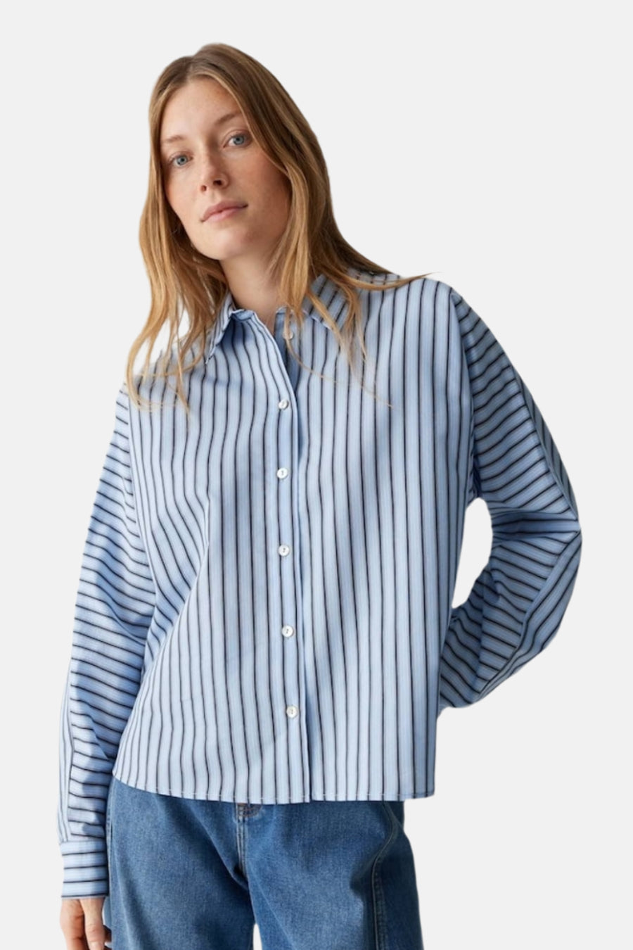 Chemise bleue rayée avec longues manches d'OPUS, à col boutonné et un jean visible.