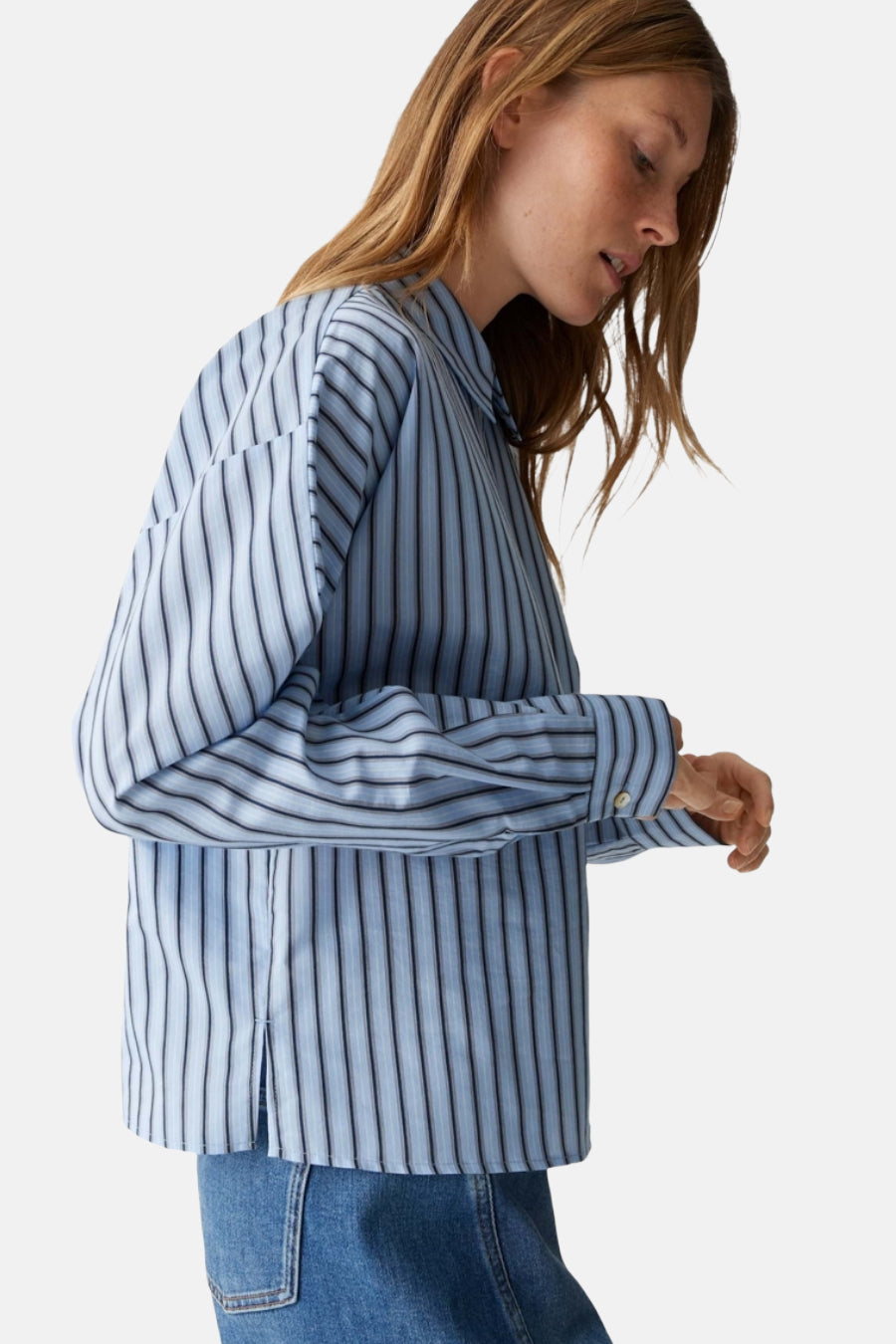 Blauw gestreept hemd met lange mouwen van OPUS, met knoopsluiting en een jeansbroek zichtbaar.
