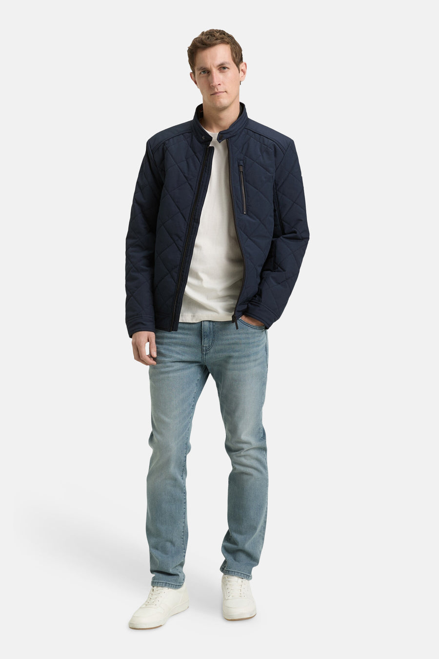 Korte blauwe jas van TOM TAILOR, met een ruitpatroon en gedragen met een wit T-shirt en lichte jeans.