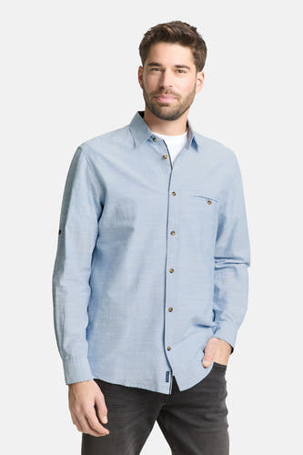 Blauw overhemd met lange mouwen van TOM TAILOR, met knoopsluiting en borstzak, gecombineerd met een wit T-shirt en donkere jeans.
