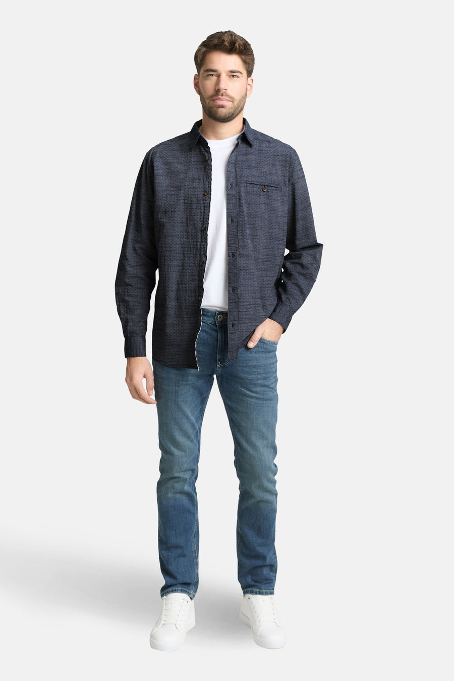 Blauw overhemd met lange mouwen van TOM TAILOR, met een subtiel patroon en gedragen over een wit T-shirt met blauwe jeans.
