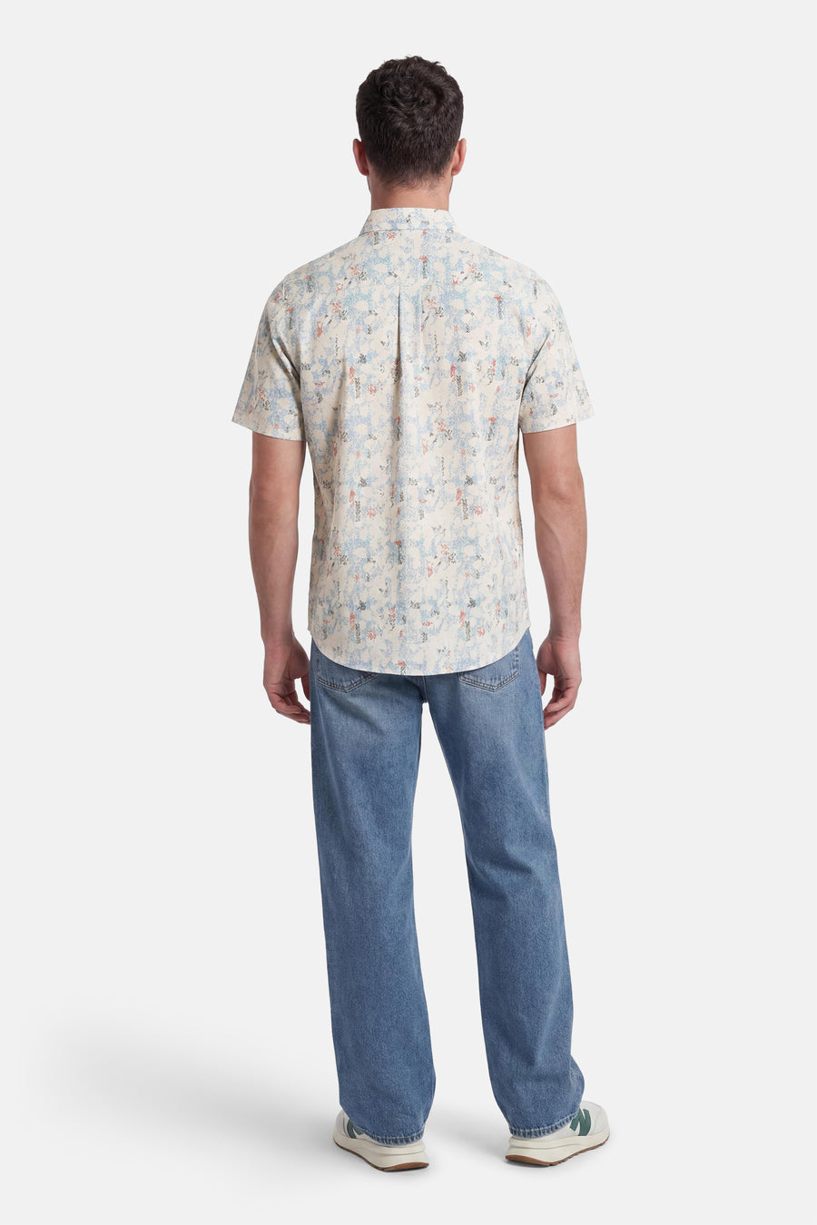 Multicolor overhemd met korte mouwen van TOM TAILOR, gedragen op de rug, met abstract patroon in blauw en oranje, gecombineerd met een wijde blauwe jeans en witte sneakers.
