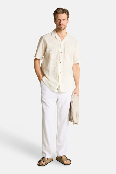 Ecru hemd met korte mouwen van TOM TAILOR, met geborduurde bladeren en resortkraag, gedragen met een witte broek en sandalen.