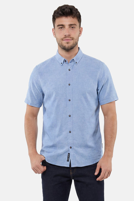 Chemise bleue à manches courtes de TOM TAILOR, avec col boutonné et boutons foncés, associée à un jean bleu foncé.