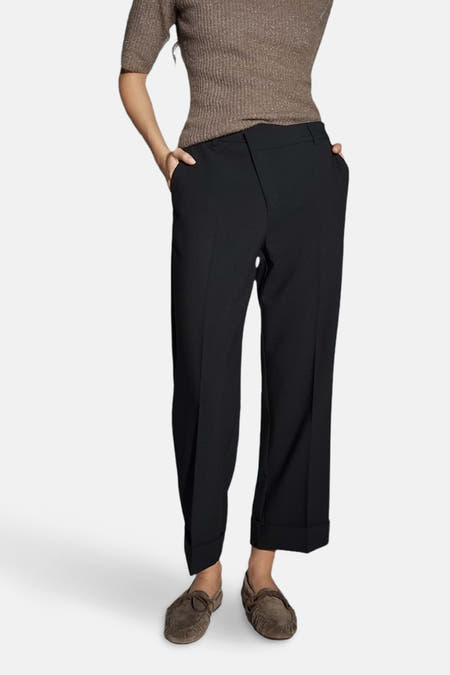 Zwarte broek van OPUS, met wijde pijpen en omgeslagen zoom, gecombineerd met een bruine top en mocassins.
