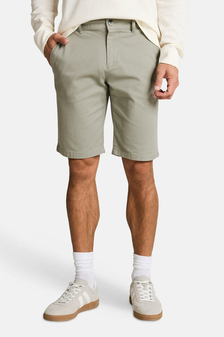 Groene chino shorts van TOM TAILOR, gedragen met een crème wafelpatroon shirt en lichte sneakers.