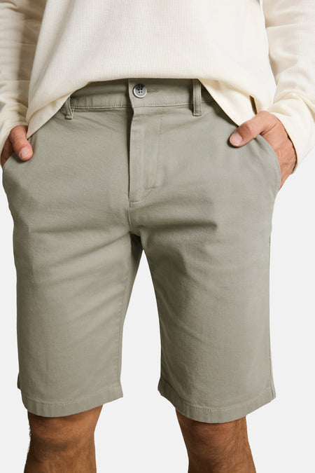 Lichtgroene shorts van TOM TAILOR van keperstof, met knoopsluiting en riemlussen, gedragen met een crèmekleurig wafelgebreid shirt.