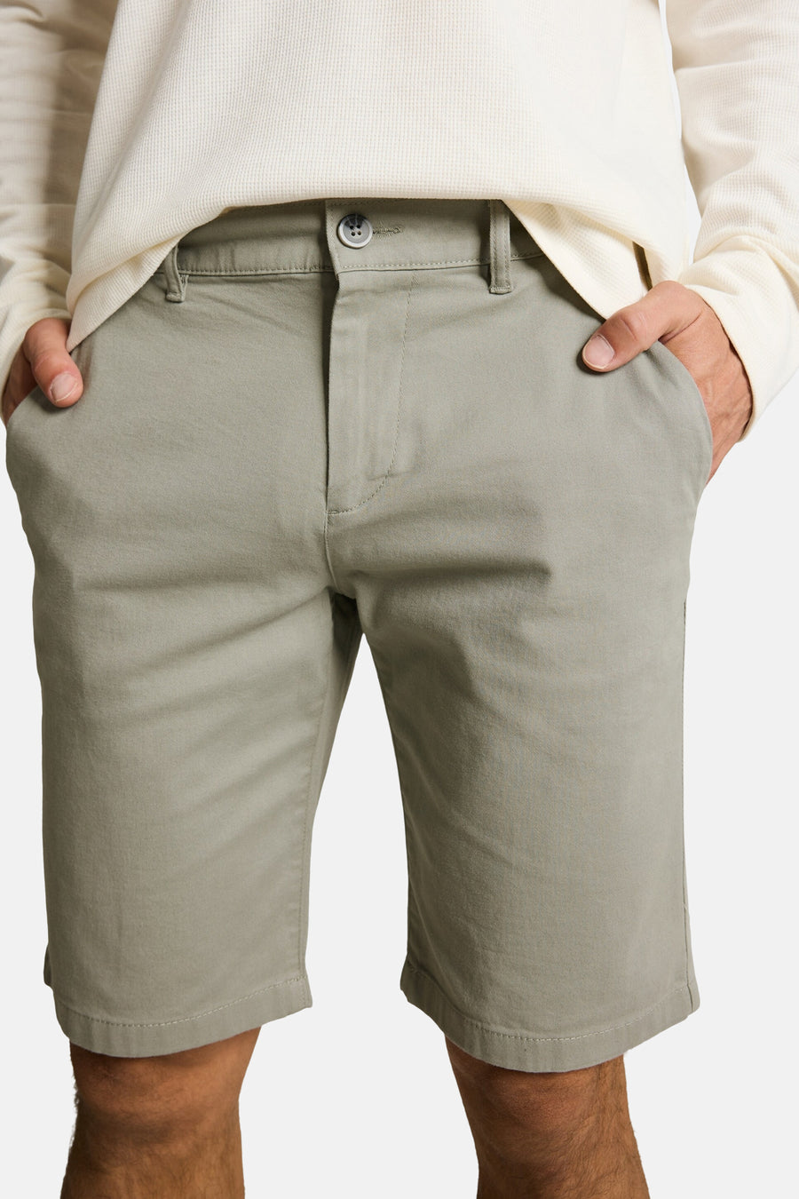 Shorts vert clair TOM TAILOR en sergé, avec fermeture à boutons et passants de ceinture, portés avec un t-shirt crème en nid d'abeille.