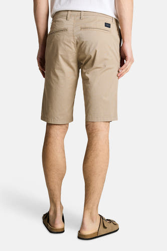 Beige bermuda van TOM TAILOR, met achterzakken en een subtiele textuur, gecombineerd met bruine sandalen.
