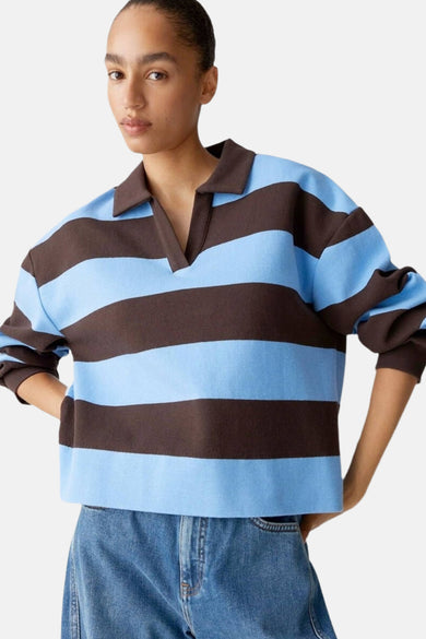 Veelkleurige trui met V-hals van OPUS, gestreept in blauw en bruin, gecombineerd met een blauwe jeans.
