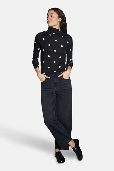 Zwart T-shirt met lange mouwen van OPUS, met witte stippen en gecombineerd met een donkere broek en schoenen.
