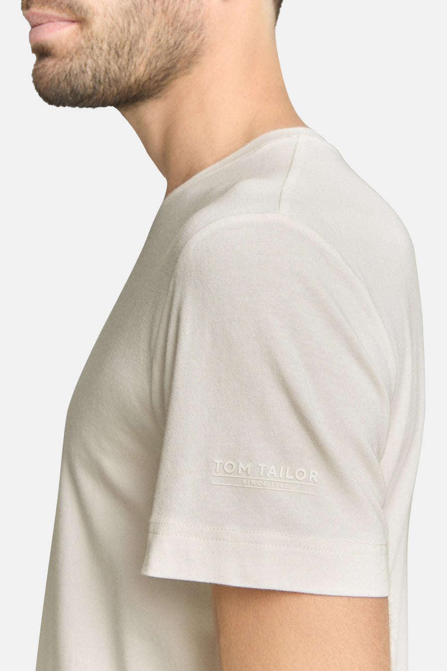 Wit T-shirt met korte mouwen van TOM TAILOR, close-up zijwaartse weergave met logo op de mouw.
