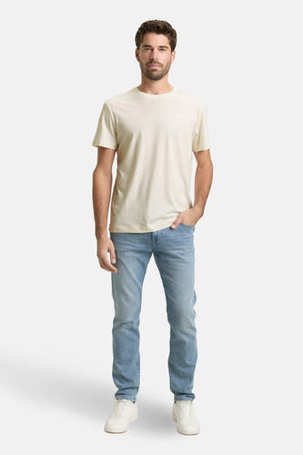 Wit T-shirt met korte mouwen van TOM TAILOR, gedragen met blauwe jeans en witte sneakers.