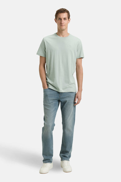 Groen T-shirt met korte mouwen van TOM TAILOR, gedragen met jeans en witte sneakers.
