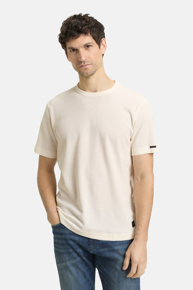T-shirt écru à manches courtes de TOM TAILOR, avec une texture subtile et porté avec un jean et des baskets blanches.