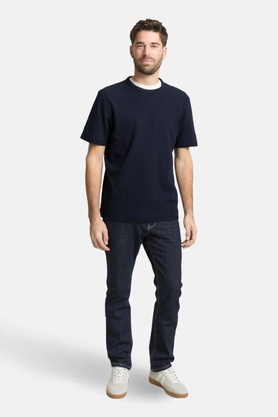 Blauw T-shirt met korte mouwen van TOM TAILOR, gedragen met donkere jeans en crèmekleurige sneakers.