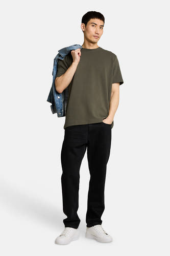 Kaki T-shirt met korte mouwen van TOM TAILOR, met subtiele ribstructuur, gedragen door een man met zwarte jeans en witte sneakers.