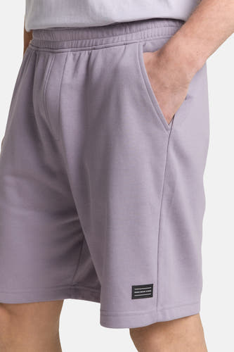 Paarse short van TOM TAILOR, met hand in de zak en logo-label op de zoom.