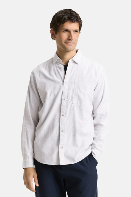 Man in wit overhemd en donkerblauwe broek.