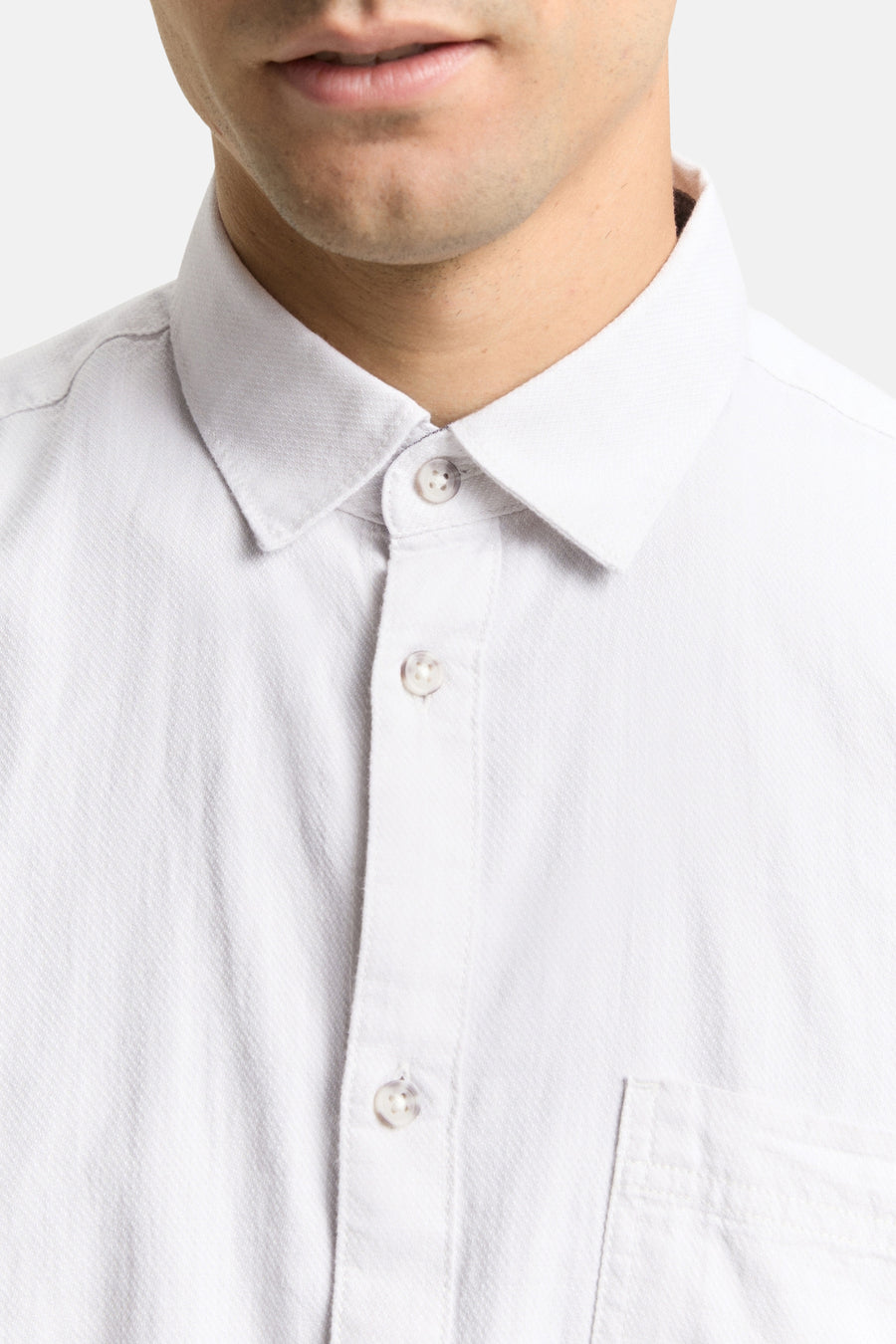 Wit overhemd met knopen en borstzak.
