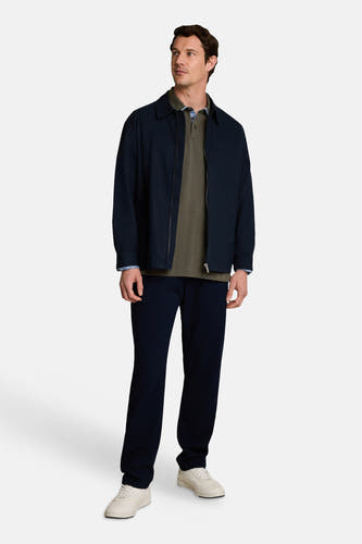Groene polo van TOM TAILOR, gedragen onder donkerblauwe jas, met witte sneakers en donkere broek, volledig lichaam, front view