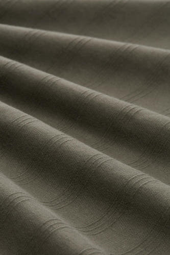 Groene polo van TOM TAILOR, close-up van fijne textuur met zachte plooien en subtiel gestreept patroon