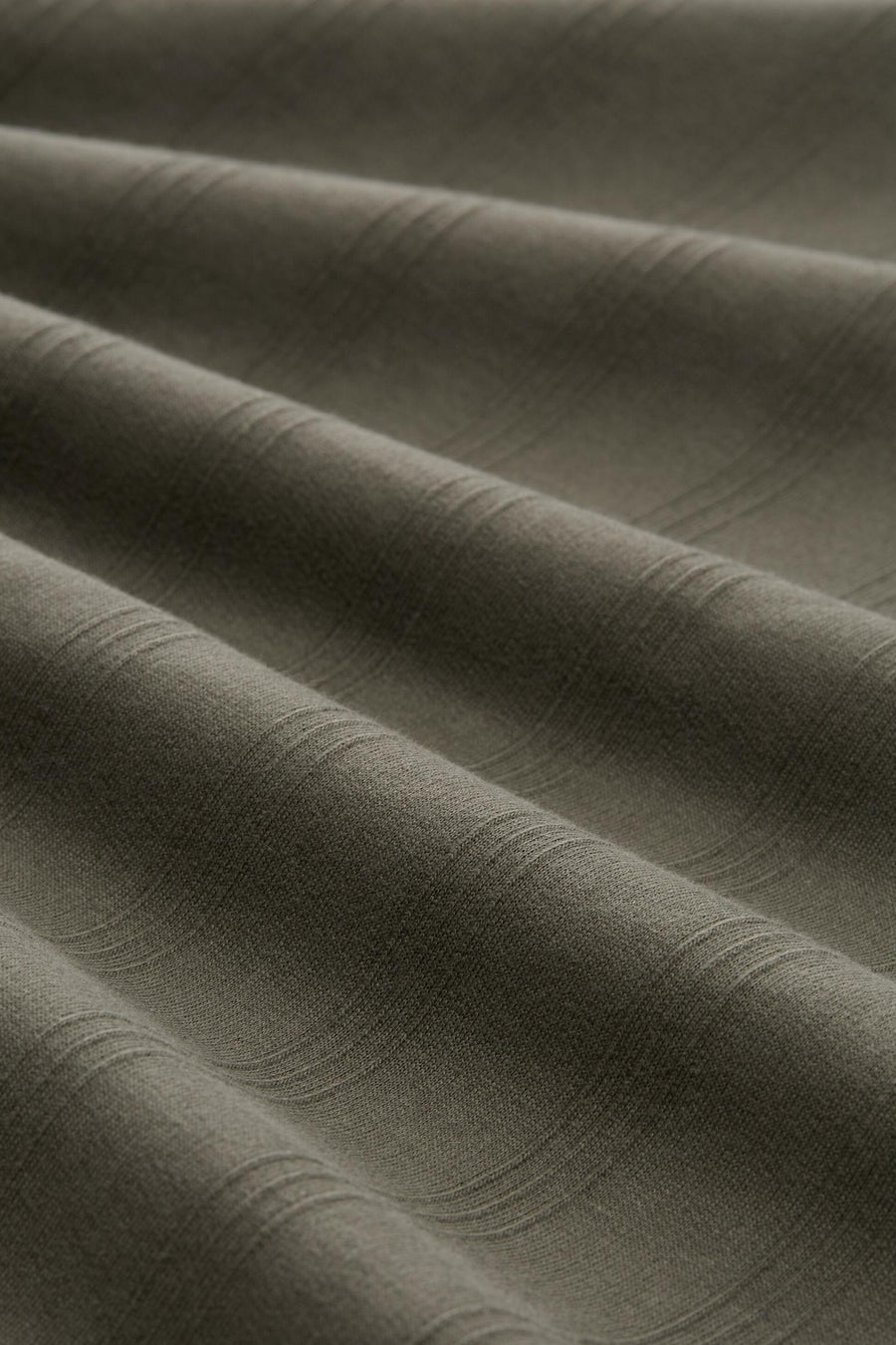 Groene polo van TOM TAILOR, close-up van fijne textuur met zachte plooien en subtiel gestreept patroon