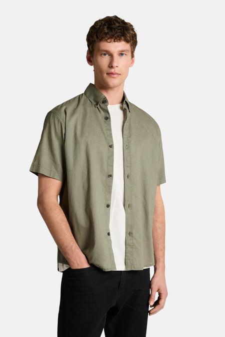 Groen overhemd met korte mouwen van TOM TAILOR, met een licht textuur en open gedragen over een wit T-shirt.