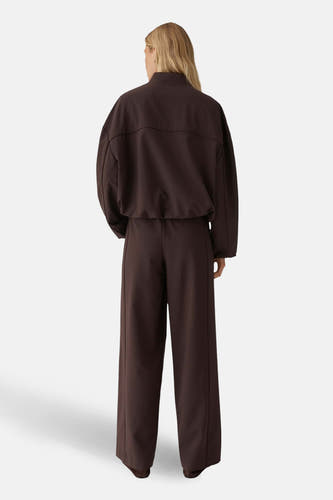 Veste courte marron d'OPUS, vue de dos, avec une coupe ample et des manches longues, portée avec un pantalon assorti.