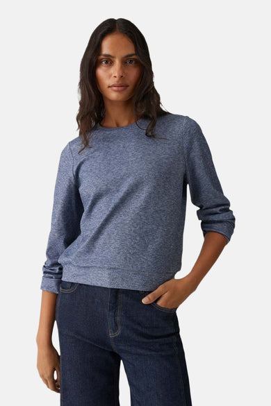 T-shirt bleu avec col rond d'OPUS, vu de dos, associé à un jean foncé.