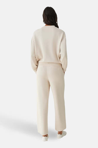 Beige pull met ronde hals van OPUS, gezien van achteren, met bijpassende broek en witte sneakers.