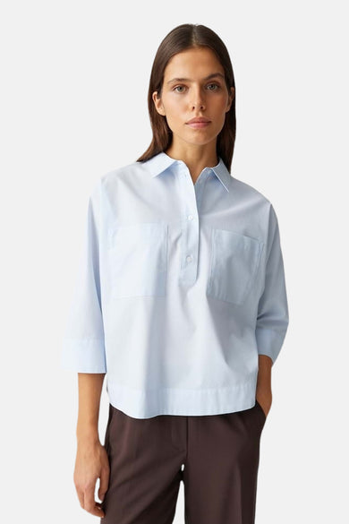 Chemisier bleu à manches courtes d'OPUS, avec deux poches poitrine et pantalon marron.