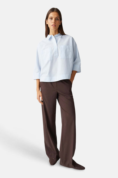 Blauw blouse met korte mouwen van OPUS, met twee borstzakken en bruine pantalon.