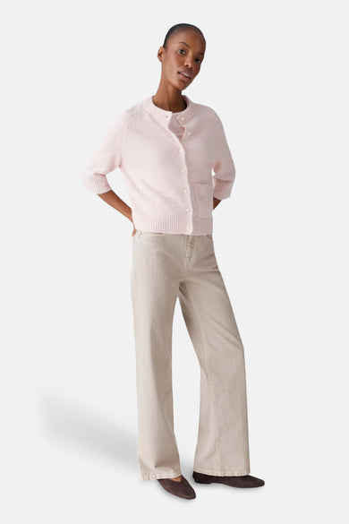 Roze gilet van OPUS, met knoopsluiting en opgestikte zakken, gecombineerd met een beige broek en bruine schoenen.
