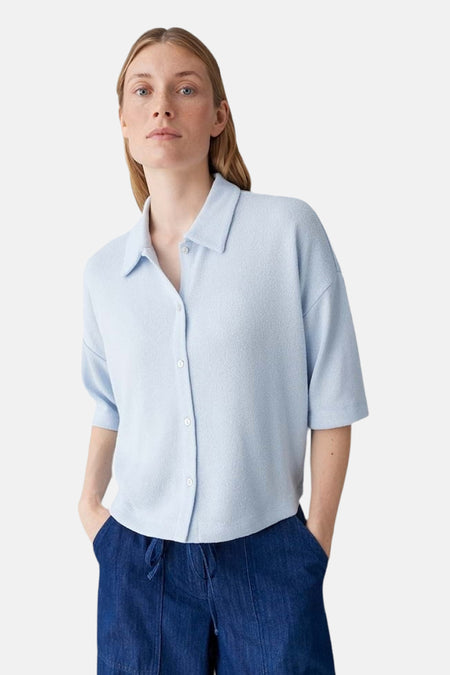 Gilet bleu d'OPUS, porté avec un polo bleu clair et un pantalon large bleu foncé à revers.