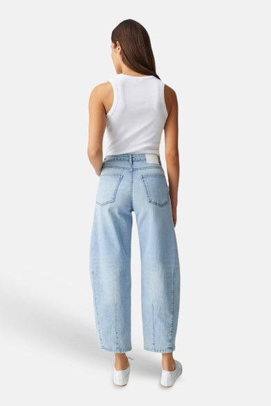 Lichte blauwe denim jeans met speciale pasvorm van OPUS, wijd uitlopend en van achteren gezien, gedragen met een witte tanktop en witte sneakers.