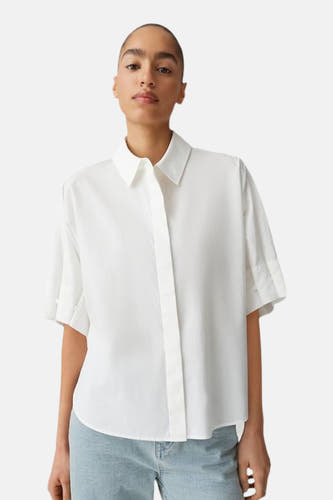 Chemise blanche OPUS à manches courtes, revers de manche et ourlet arrondi, portée avec un jean clair.