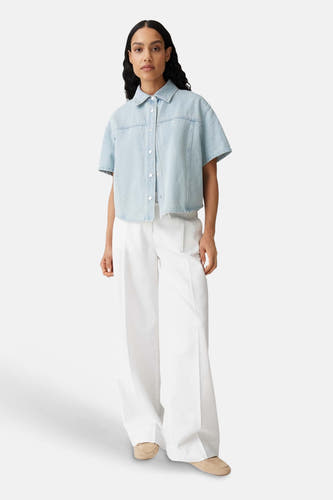 Ecru broek van OPUS met wijde pijpen, gestyled met een lichtblauwe spijkerblouse en beige loafers.