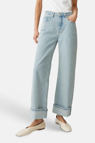 Lichtblauwe denim wijde pijpen jeans van OPUS met omgeslagen zomen, gestyled met crèmekleurige flats.
