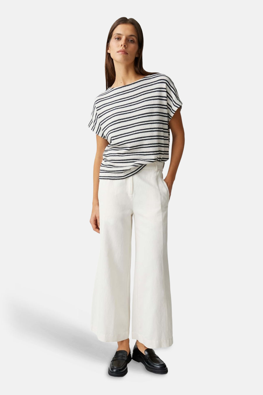 Meerkleurig T-shirt van OPUS met bootkraag, korte mouwen en zwart-witte strepen, gedragen met witte broek en zwarte loafers.