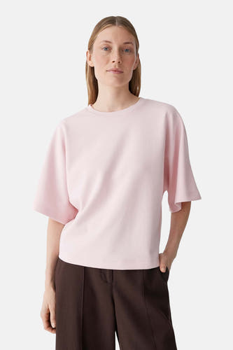 T-shirt rose OPUS coupe ample, manches larges jusqu'au coude et col rond, vu de dos, combiné avec un pantalon marron.
