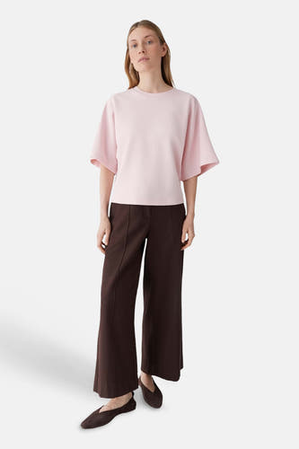 Roze T-shirt van OPUS met vlindermouwen en losvallend model, gedragen met donkerbruine broek.