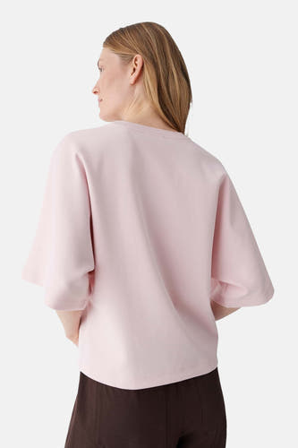 Roze T-shirt van OPUS met losse pasvorm, wijde mouwen tot de elleboog en ronde hals, van achteren gezien, gecombineerd met een bruine broek.