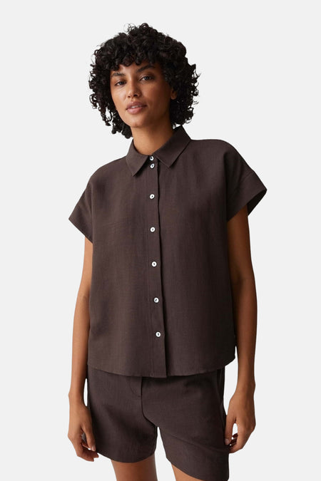 Chemise marron à manches courtes OPUS avec col, coupe ample et pli au dos, portée avec un pantalon assorti.