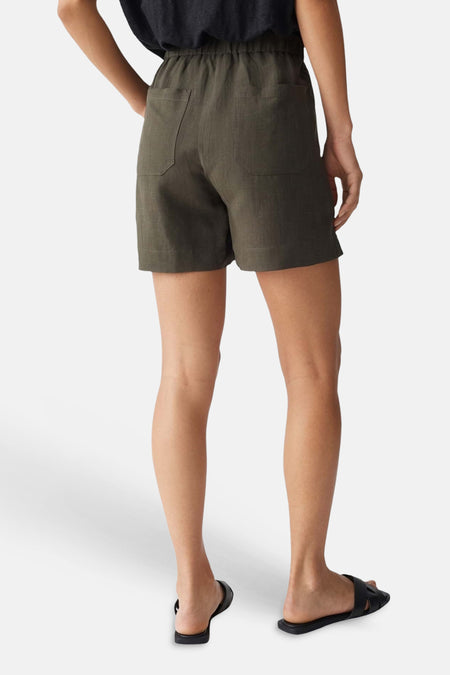 Groene formele korte broek van OPUS, achterzijde met twee zakken, elastische taille, model in donkere top en zwarte slippers