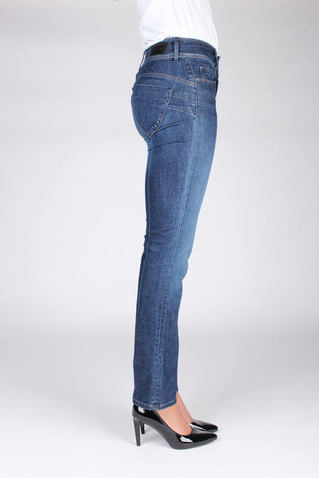 Slim fit jeans in donkerblauw denim van Salsa Jeans, met subtiele stiksels en zwarte pumps.
